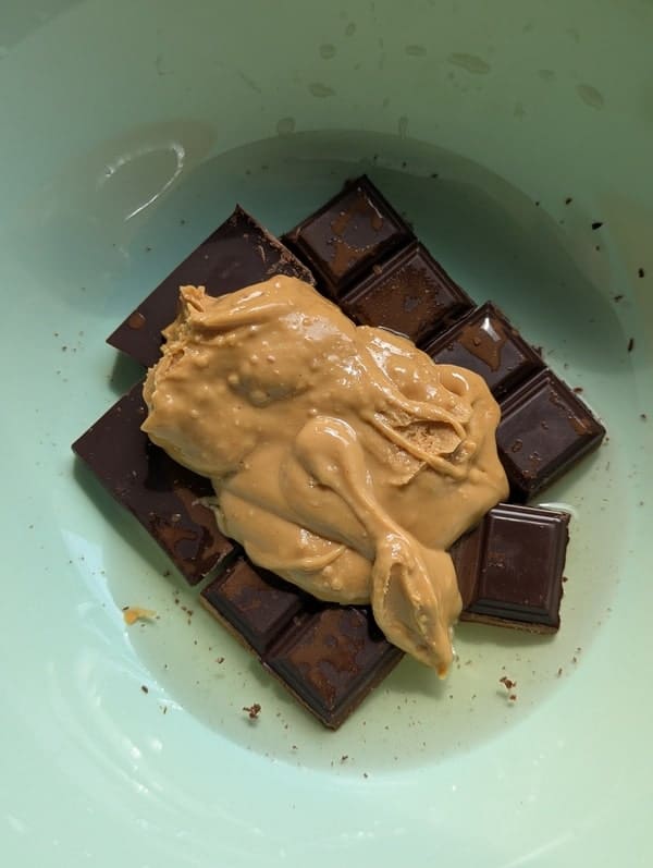 Préparation d’un nappage chocolat-beurre de cacahuète avec de l’eau à faire fondre